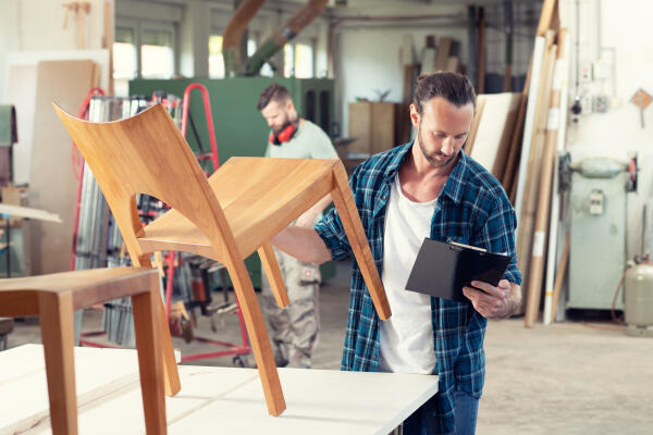 Holzmechaniker überprüft gefertigten Stuhl