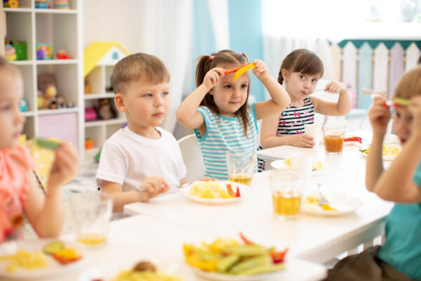 Erzieher beaufsichtigen die Kinder beim Essen