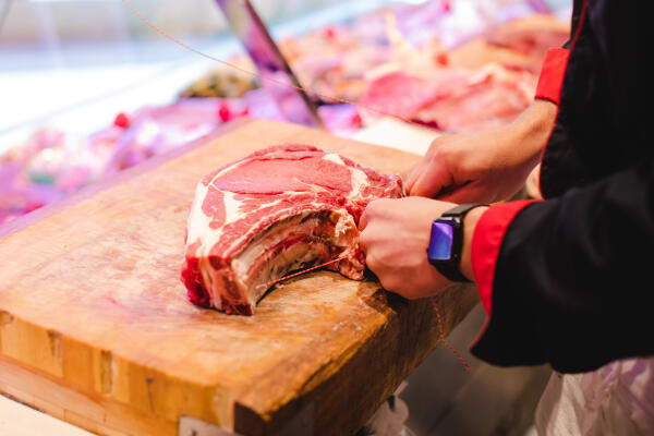 Fleischer bereitet Fleisch für den Verkauf zu