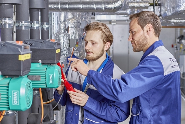 TECTRION GmbH: Der betriebliche Ausbilder erklärt dem Mechatroniker-Azubi etwas direkt in der Anlage vor Ort.
