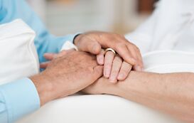 Pflege Studium – 2 Menschen halten sich die Hände Pflege Studium – 2 Menschen halten sich die Hände