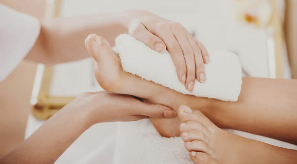 Fachkraft für Beauty und Wellness kümmert sich um die Fußpflege