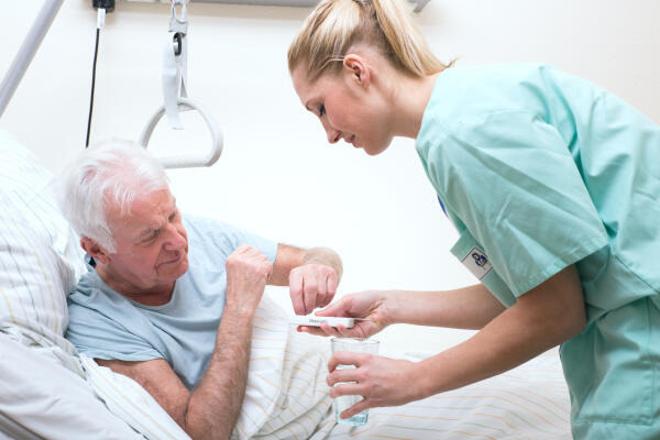 Krankenpflegerin bringt Patient Medikamente Krankenpflegerin bringt Patient Medikamente
