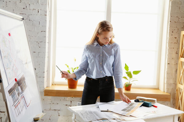 Assistentin für Innenarchitektur arbeitet an einem Konzept für einen Innenraum Assistentin für Innenarchitektur arbeitet an einem Konzept für einen Innenraum