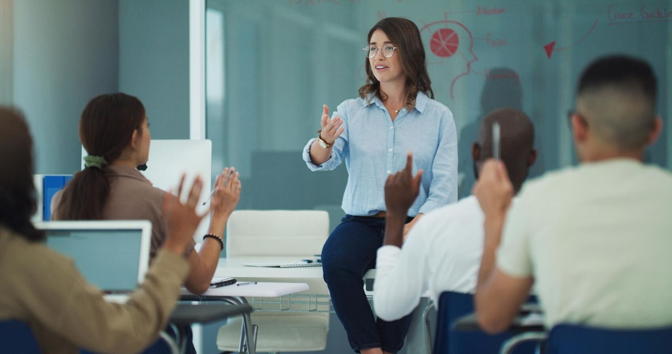 Dozentin erklaert den Studierenden etwas im Seminar