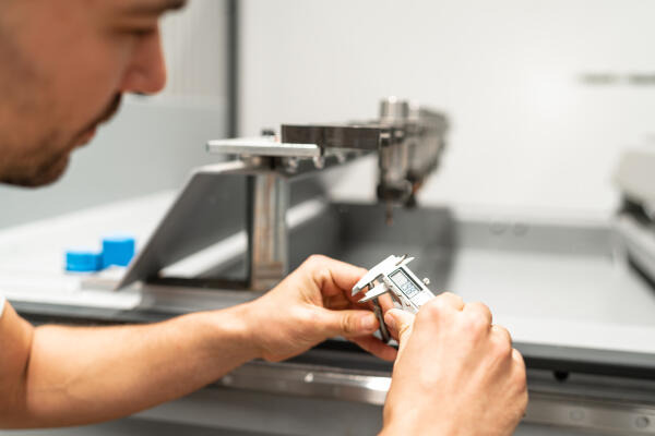 Präzisionswerkzeugmechaniker misst Durchmesser vom Fräser Präzisionswerkzeugmechaniker misst Durchmesser vom Fräser