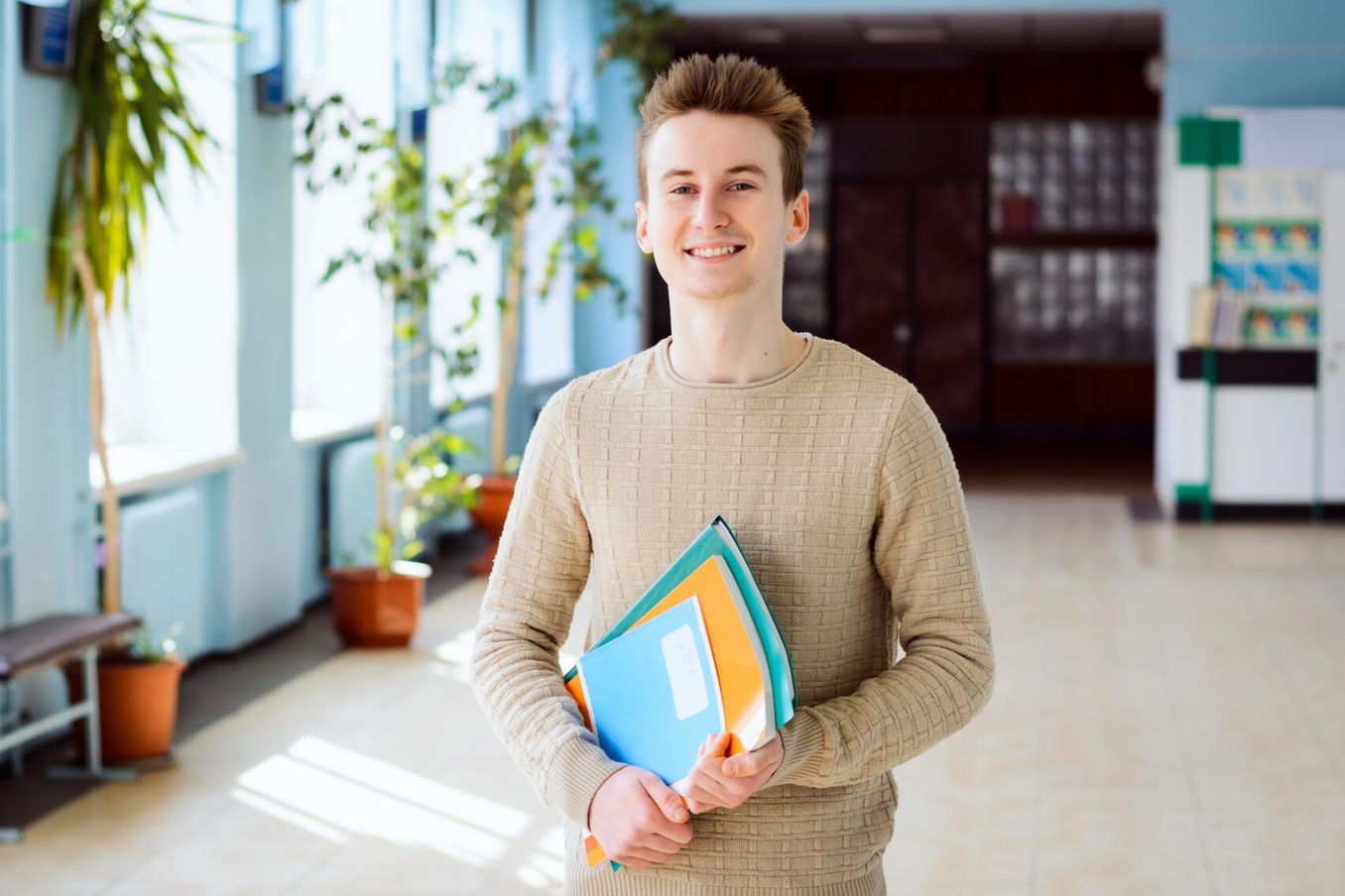 Ethnologie Studium – Student laechelt im Flur der Universitaet