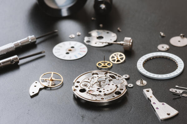Uhrmacher arbeiten mit verschiedensten Bauteilen der Uhr Uhrmacher arbeiten mit verschiedensten Bauteilen der Uhr