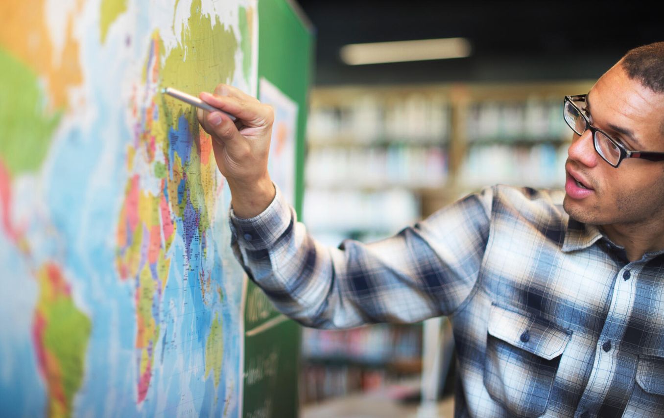 Geographie – Student betrachtet große Weltkarte