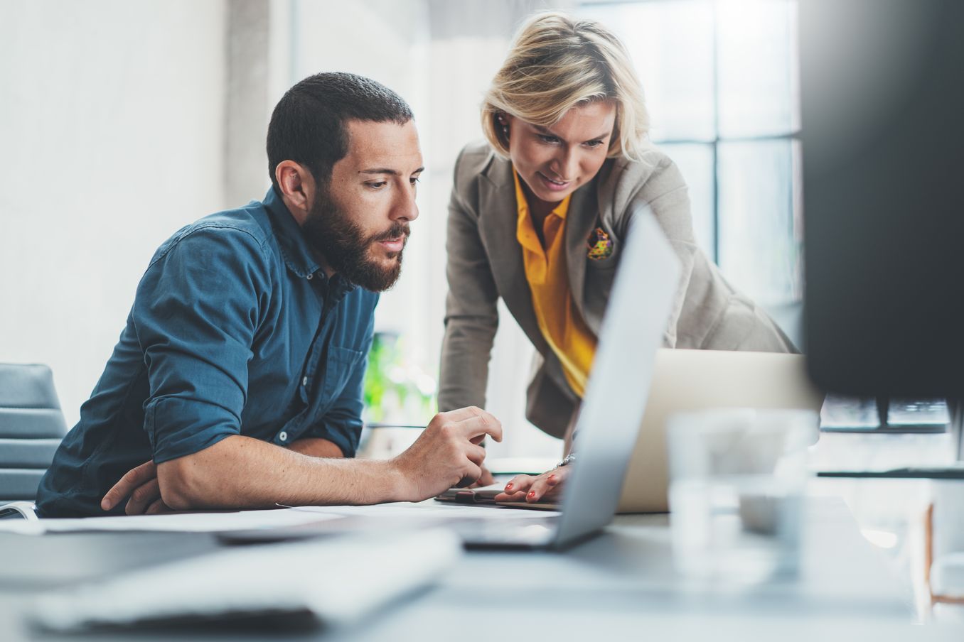 Finanzen Studium – ein Mann und eine Frau gucken auf einen Laptop