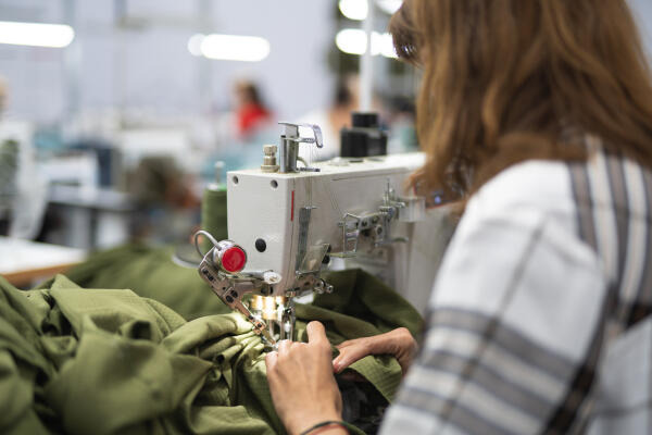 Polster- und Dekorationsnäherin näht mit einer Nähmaschine Polster- und Dekorationsnäherin näht mit einer Nähmaschine