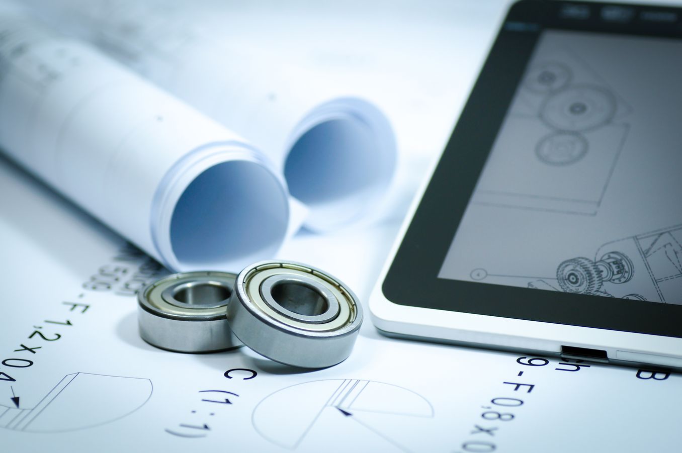 Produktdesign Studium – zwei Kugellager liegen auf Skizzen neben einem Tablet