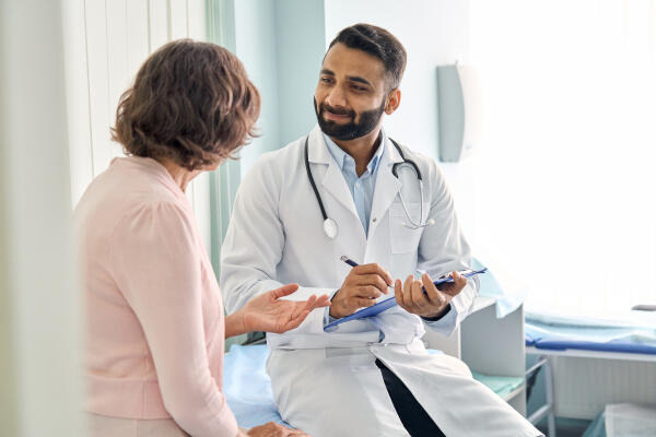 Rheumatologe in Gespräch mit Patientin Rheumatologe in Gespräch mit Patientin