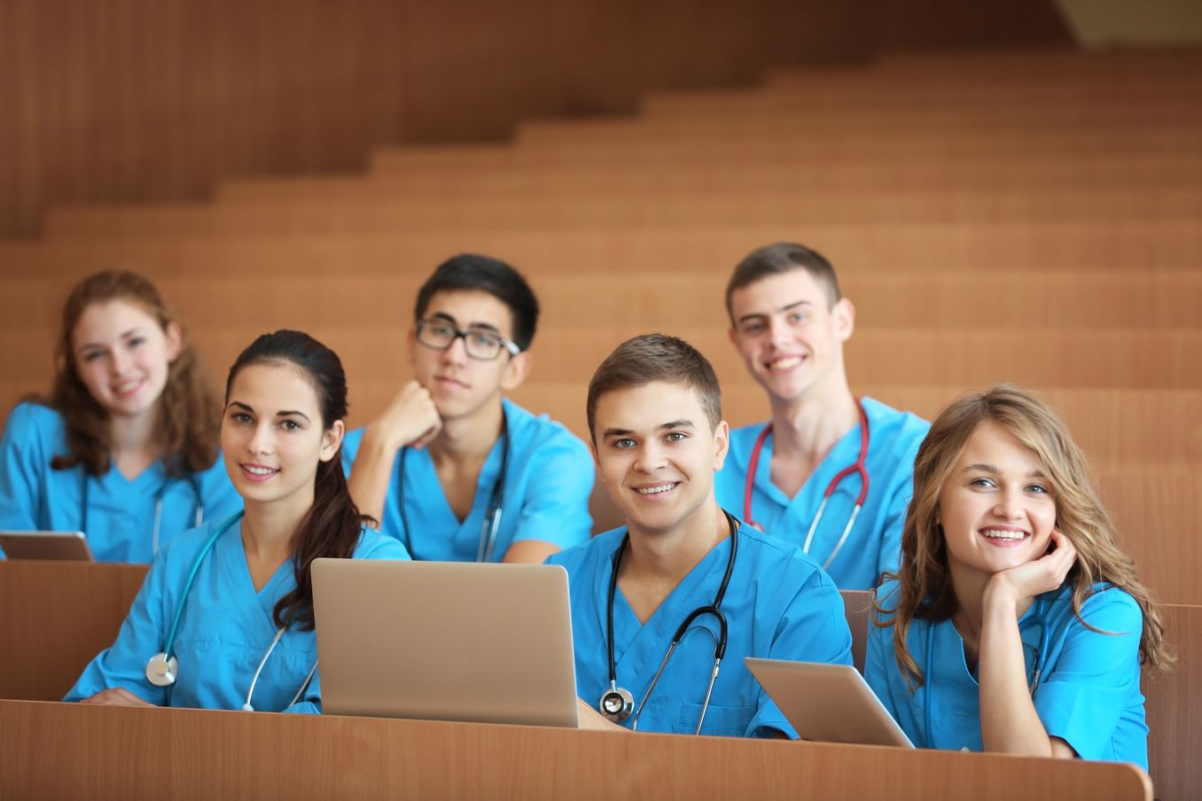 Pflegemanagement Studium – Studierende in Kasack sitzen im Hoersaal