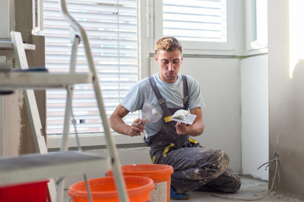 Bauten- und Objektbeschichter tra¨gt Putz auf Kelle auf Bauten- und Objektbeschichter tra¨gt Putz auf Kelle auf