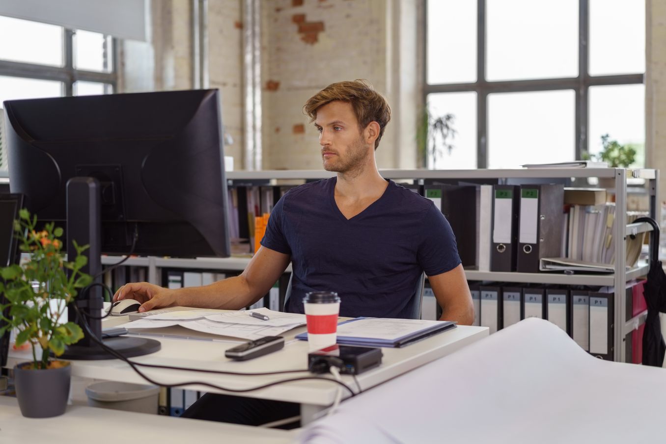 Controlling Studium – Controller sitzt im Buero vor seinem Computer