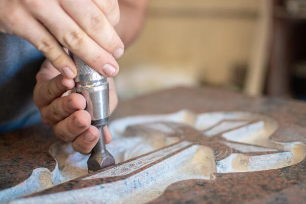 Naturwerksteinmechaniker veredelt Grabstein mit Gravur