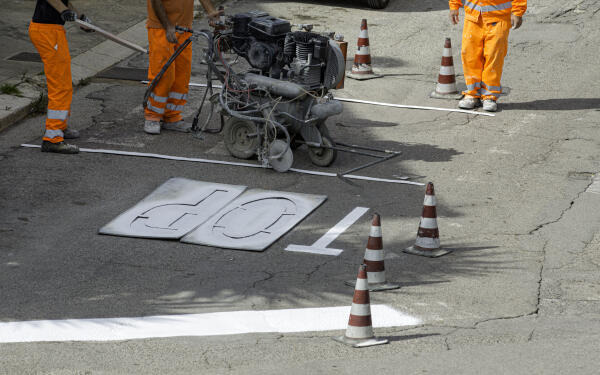 Straßenwärter bringen Straßenmarkierung an