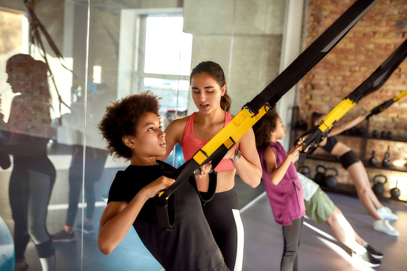 Sportwissenschaft Studium – Studierende trainieren an TRX-Baendern