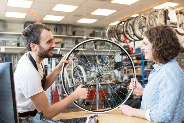 Fahrradmonteur berät Kundin Fahrradmonteur berät Kundin