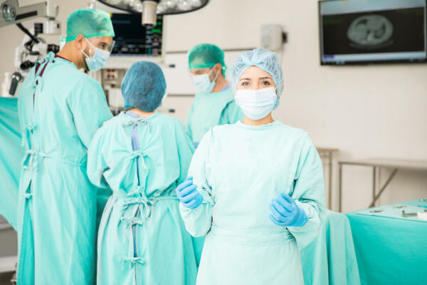 Den operierenden Ärzten Instrumente reichen Den operierenden Ärzten Instrumente reichen