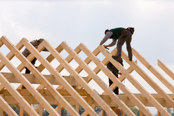 Zimmerer arbeitet auf Dachbalken Zimmerer arbeitet auf Dachbalken