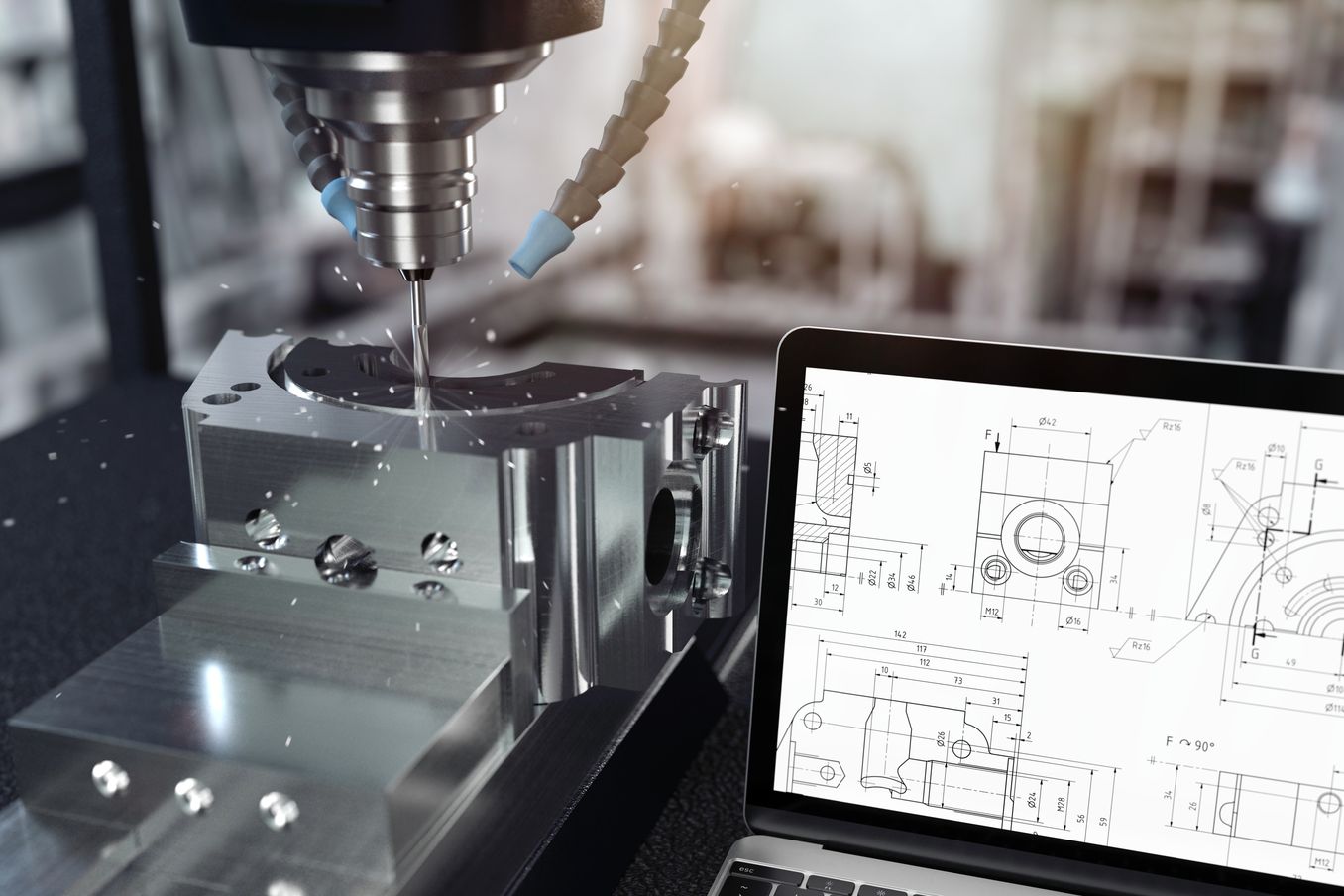 Technik Studium – Bohrmaschine neben Laptop der eine Skizze zeigt