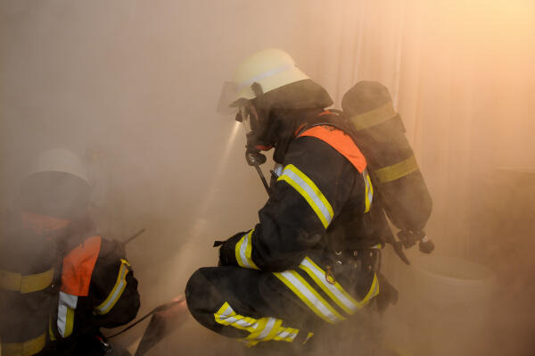 Feuerwehrmänner retten Verletzte aus brennendem Haus Feuerwehrmänner retten Verletzte aus brennendem Haus