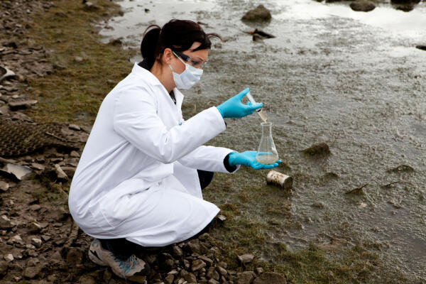 Fachkraft für Wasserwirtschaft entnimmt Proben