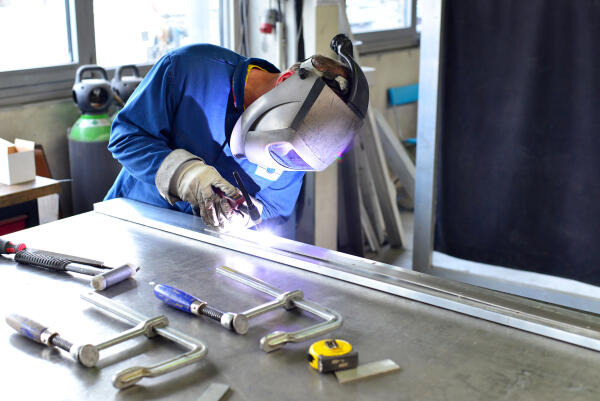 Holzblasinstrumentenmacher schweißt Metall Holzblasinstrumentenmacher schweißt Metall