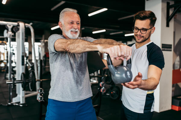 Sport- und Fitnesskaufmann erklärt richtige Ausführung einer Übung Sport- und Fitnesskaufmann erklärt richtige Ausführung einer Übung