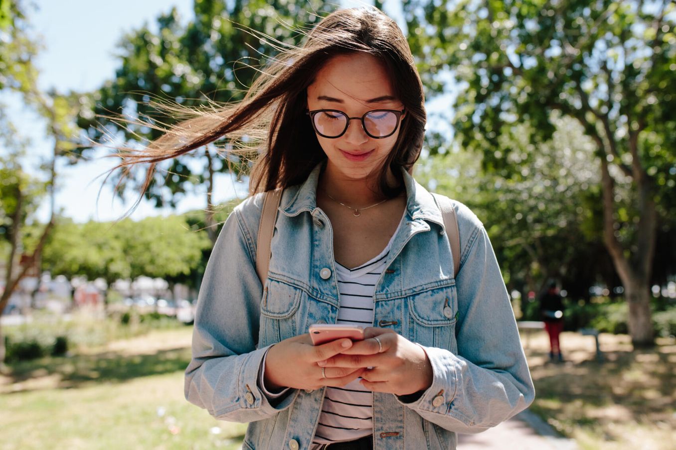 Junge Frau informiert sich am Smartphone über Studienplatz