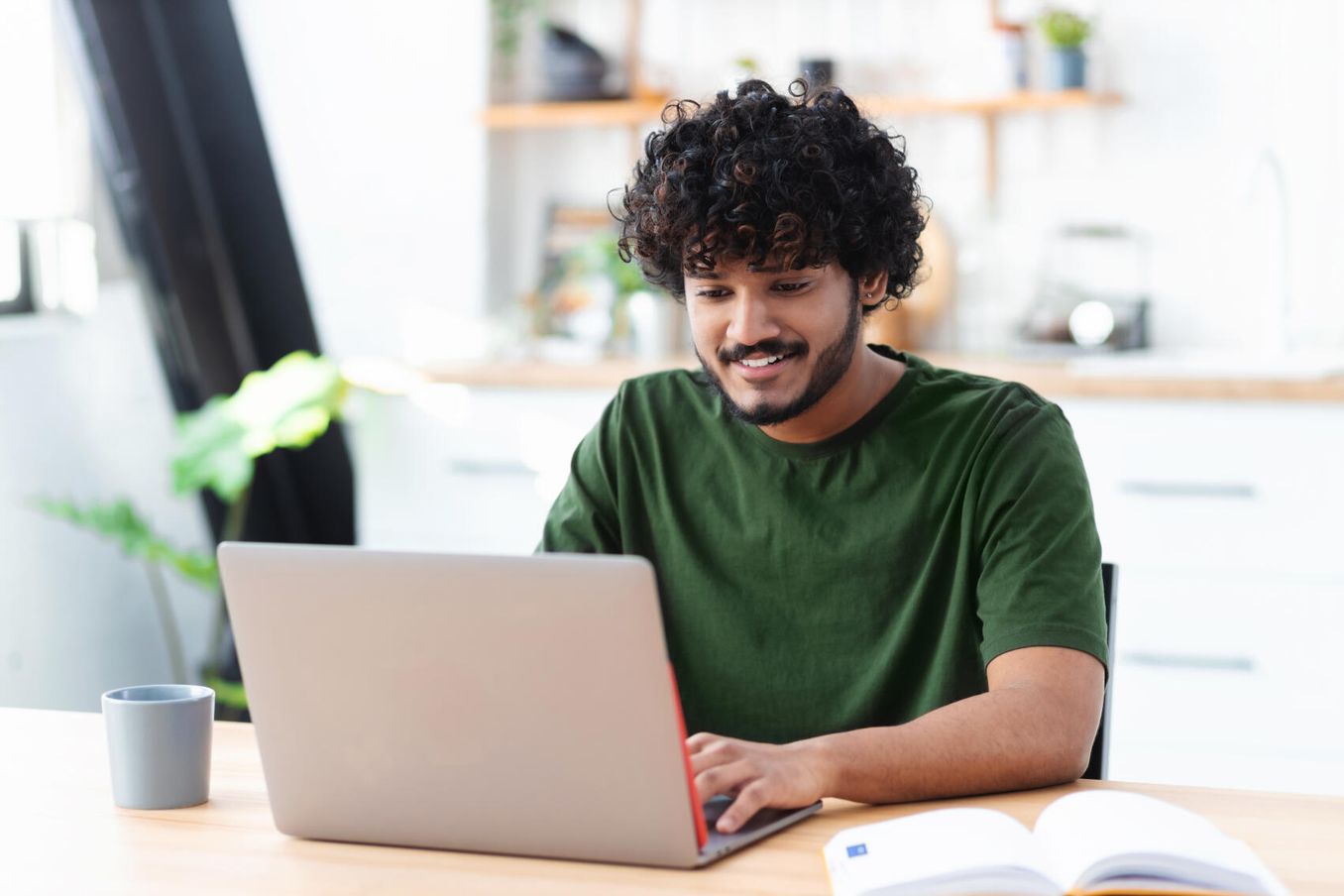 Junger Mann checkt online seine Studienmoeglichkeiten