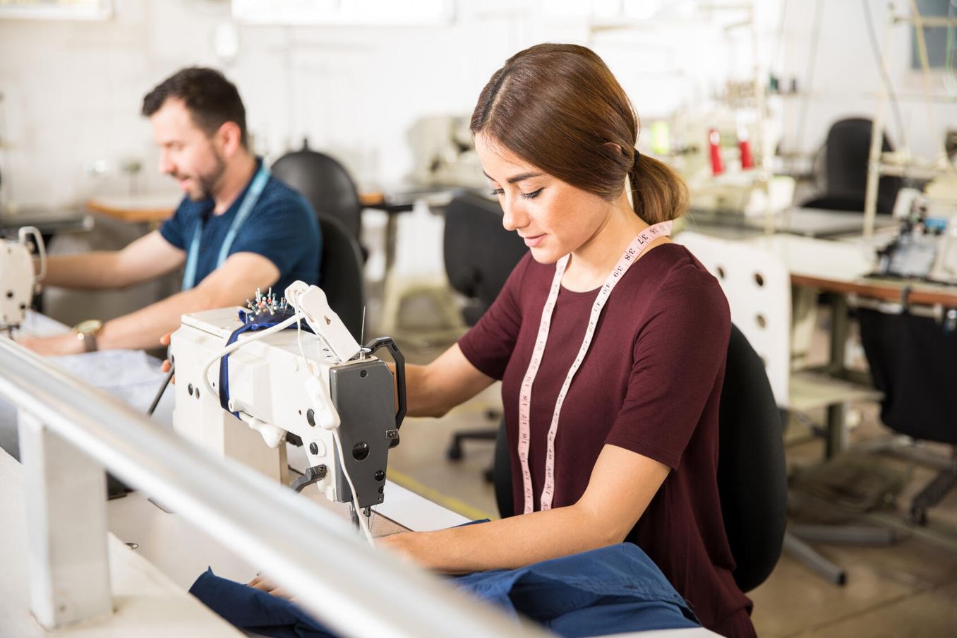 Studentin naeht Kleidungsstück in ihrem Modedesign Studium