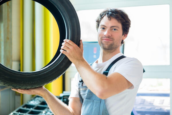 Mechaniker mit Reifen Mechaniker mit Reifen