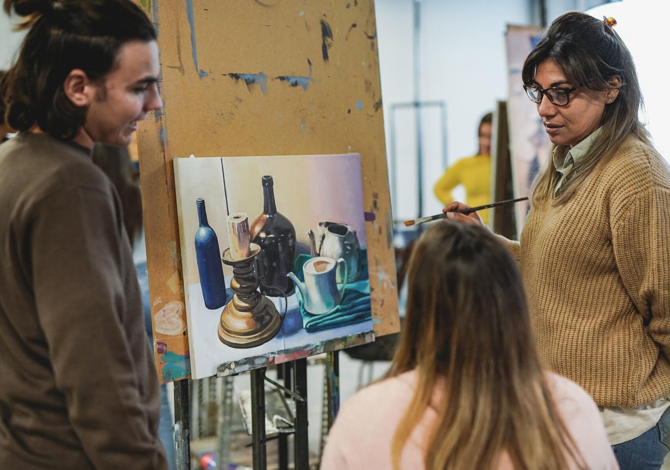 Studiengaenge mit Kunst – drei Personen betrachten ein gemaltes Stillleben
