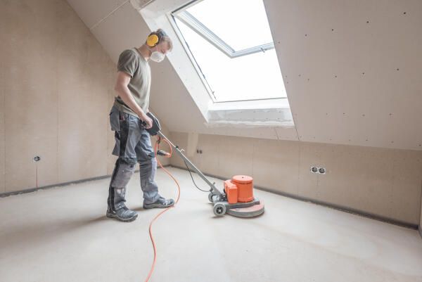Estrichleger arbeiten mit technischen Geräten und Maschinen