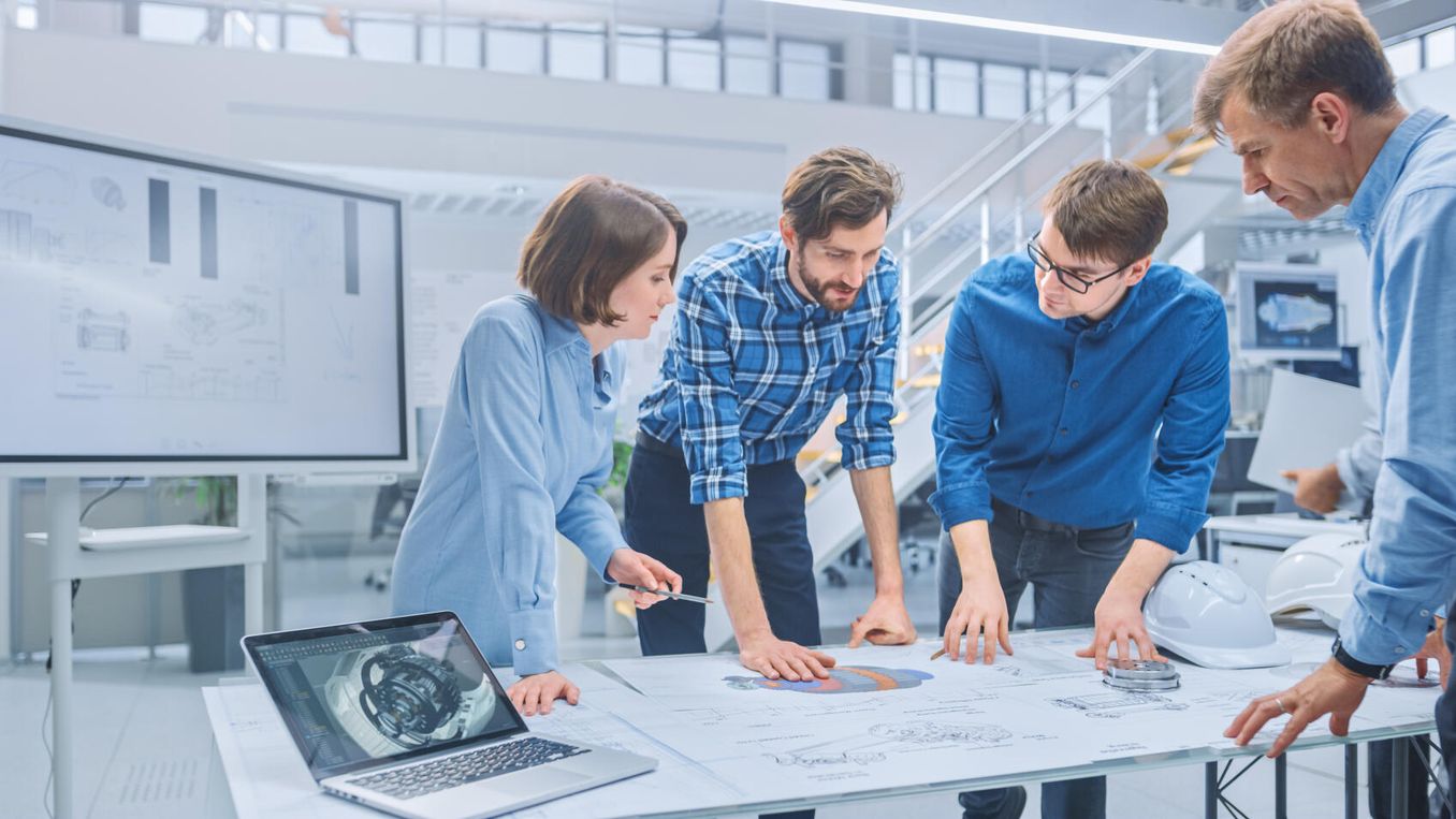 Technischer Systemplaner bespricht Plan mit Kollegen