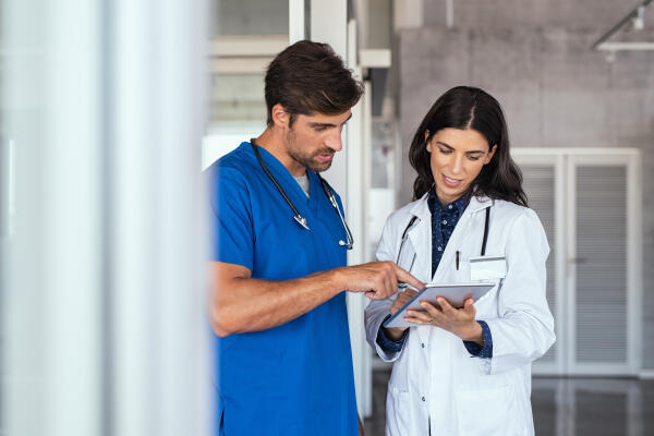 Pfleger und Ärztin besprechen Krankenakten Pfleger und Ärztin besprechen Krankenakten