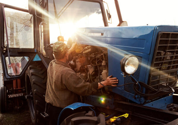 Land- und Baumaschinenmechatroniker inspiziert Traktor Land- und Baumaschinenmechatroniker inspiziert Traktor