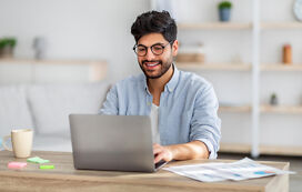 Junger Mann recherchiert zu Doktorarbeit Aufbau am Laptop Junger Mann recherchiert zu Doktorarbeit Aufbau am Laptop