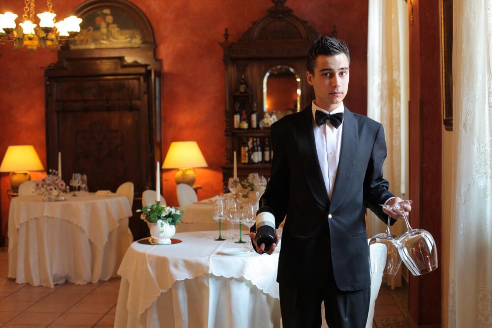 Fachkraft für Gastronomie – Mann serviert Rotwein