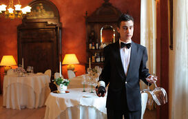 Fachkraft für Gastronomie – Mann serviert Rotwein Fachkraft für Gastronomie – Mann serviert Rotwein