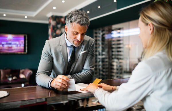 Hotelgäste beim Einchecken unterstützen Hotelgäste beim Einchecken unterstützen