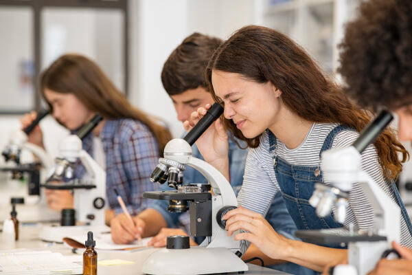 Natur- und Umweltpädagogin mikroskopiert mit Schülern