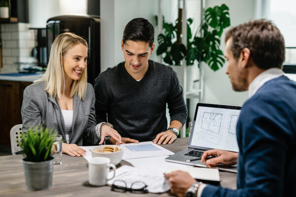Immobilienassistent bespricht Wohnungsdetails mit Kunden Immobilienassistent bespricht Wohnungsdetails mit Kunden