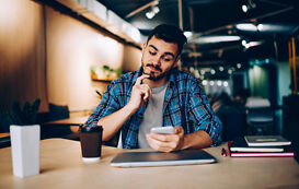 Generation Z Werte – junger Mann guckt auf sein Handy Generation Z Werte – junger Mann guckt auf sein Handy