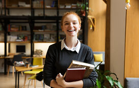 Literaturwissenschaft Studium – Junge Frau mit Büchern lächelt Literaturwissenschaft Studium – Junge Frau mit Buechern laechelt