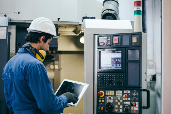 Stanz- und Umformmechaniker arbeitet an Maschine Stanz- und Umformmechaniker arbeitet an Maschine