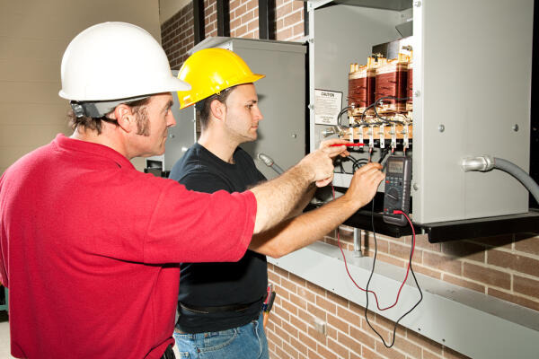 Eletroniker prüfen Spannungsverlauf von Bauteilen Eletroniker prüfen Spannungsverlauf von Bauteilen